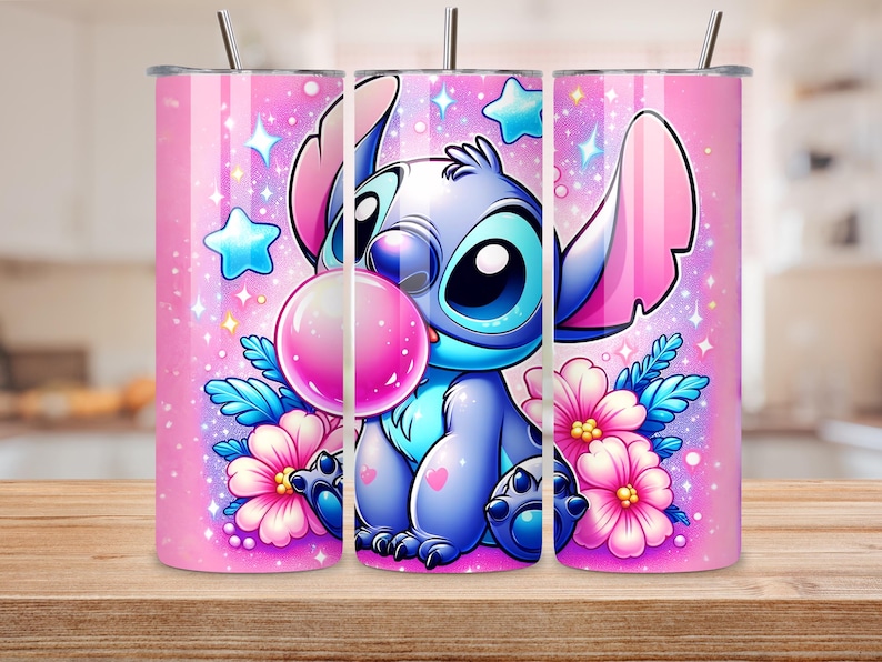 Puede incluir: Un vaso rosa con un personaje de dibujos animados soplando una burbuja. El personaje es azul con ojos y orejas grandes, rodeado de flores rosas, estrellas y brillos. El vaso tiene una pajita plateada y est&aacute; sobre una superficie de madera.