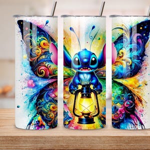 May include: Three white stainless steel tumblers with a colorful butterfly and Stitch design. The design features a blue Stitch character holding a lantern, set against vibrant wings with swirls of color. Each tumbler has a silver straw.
