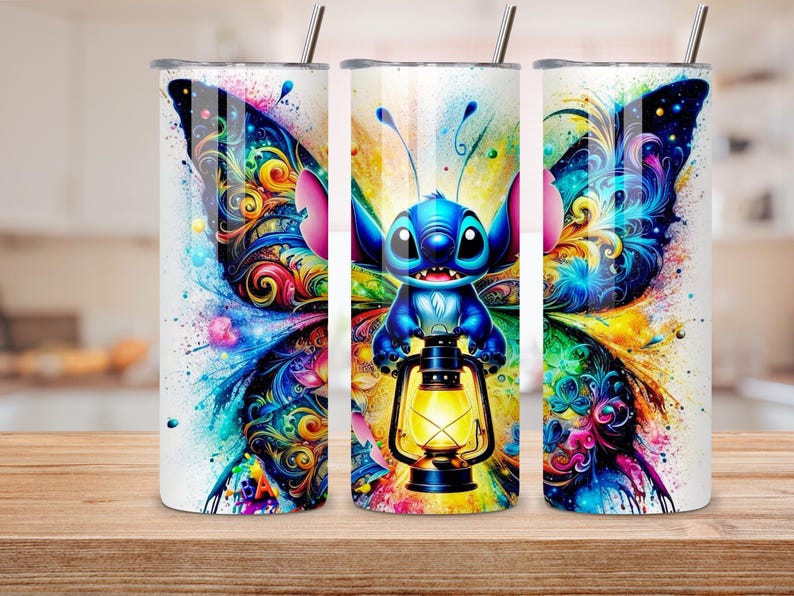 May include: Three white stainless steel tumblers with a colorful butterfly and Stitch design. The design features a blue Stitch character holding a lantern, set against vibrant wings with swirls of color. Each tumbler has a silver straw.