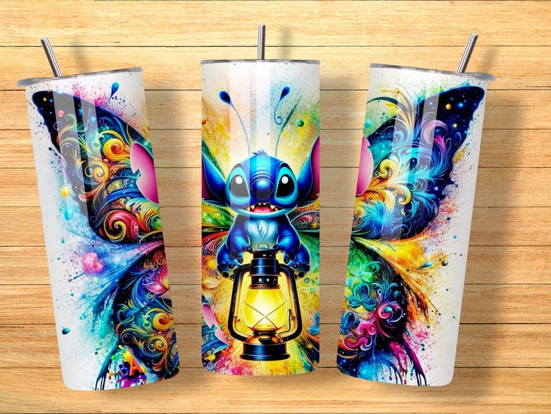 May include: Three white insulated tumblers with a colorful butterfly and Stitch design. The design features a blue Stitch character holding a lantern, set against a vibrant watercolor background with splashes of blue, yellow, pink, and green.