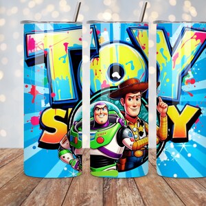 K&ouml;nnte beinhalten: Ein blauer Becher mit den Worten "TOY STORY" in gro&szlig;en, farbenfrohen Buchstaben. Der Becher zeigt Bilder von Woody und Buzz Lightyear. Das Design umfasst einen Edelstahlstrohhalm und einen Deckel. Der Becher ist etwa 20 cm hoch.