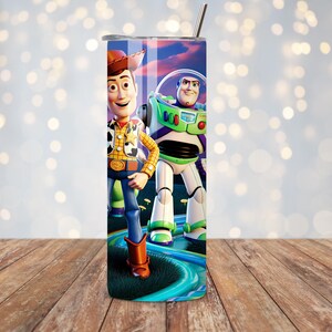 Puede incluir: Un vaso de acero inoxidable con Woody y Buzz Lightyear de Toy Story. El vaso tiene un dise&ntilde;o colorido con los personajes de pie sobre una superficie azul y verde. Incluye una pajita plateada y una tapa.