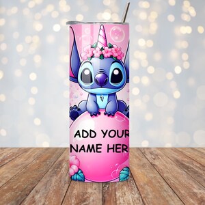 May include: A pink and blue tumbler featuring a cartoon character with a unicorn horn and flower crown. The tumbler has the text "ADD YOUR NAME HERE" on a pink bubble. A silver straw is included.