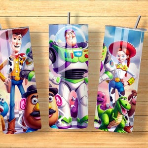 May include: Three cylindrical tumblers with metal straws featuring a colorful graphic print of Toy Story characters including Woody, Buzz Lightyear, Jessie, Mr. Potato Head, Rex, and Slinky Dog against a blue sky and checkered floor background.