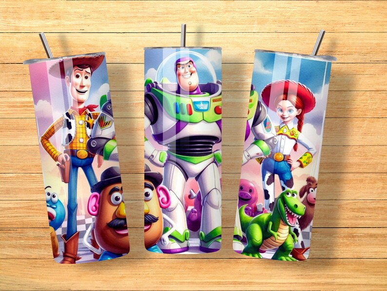 May include: Three cylindrical tumblers with metal straws featuring a colorful graphic print of Toy Story characters including Woody, Buzz Lightyear, Jessie, Mr. Potato Head, Rex, and Slinky Dog against a blue sky and checkered floor background.