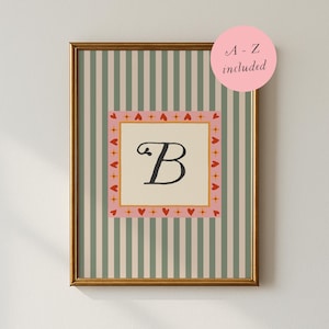 Könnte beinhalten: Gerahmter Kunstdruck mit dem Buchstaben "B" in einer dekorativen Schriftart. Das Kunstwerk hat einen rosa-cremefarbenen Rand mit roten Herzen und einen gestreiften grün-cremefarbenen Hintergrund. Ein rosa Kreis mit dem Text "A - Z included" befindet sich in der oberen rechten Ecke.
