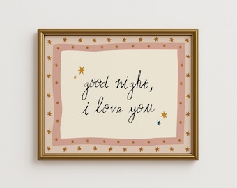 Könnte beinhalten: Ein gerahmter Druck mit den Worten "good night, I love you" in schwarzer Schrift. Der Druck hat einen cremefarbenen Hintergrund mit einem rosa Rand und goldenen Sternen. Der Rahmen ist goldfarben.