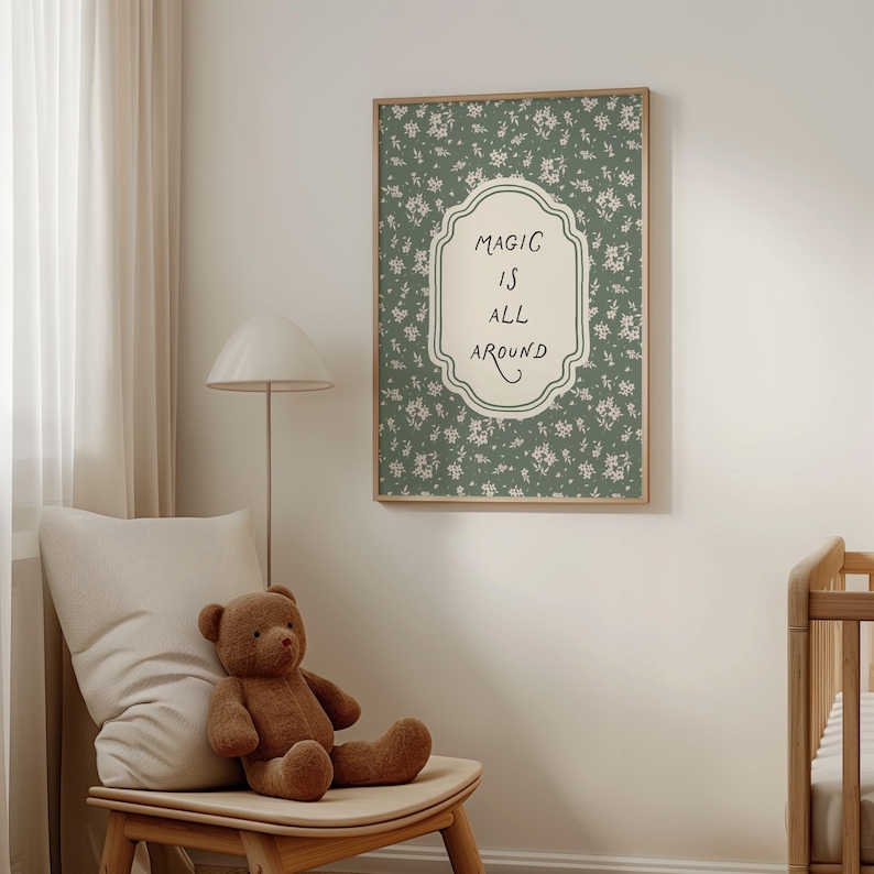 K&ouml;nnte beinhalten: Ein gerahmter Wandkunstdruck mit den Worten "MAGIC IS ALL AROUND" in einem dekorativen Rahmen. Der Hintergrund ist ein gr&uuml;nes Blumenmuster. Ein brauner Teddyb&auml;r sitzt auf einem Holzstuhl mit einem Kissen.