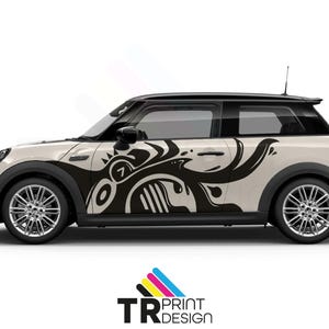 May include: A cream Mini Cooper featuring a black abstract design on its side. The design incorporates swirls, shapes, and the number 7. The car has black tyres and a black roof. The logo "TR PRINT DESIGN" is at the bottom.
