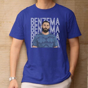 A blue t-shirt with a graphic design featuring a man with a beard wearing a patterned shirt.