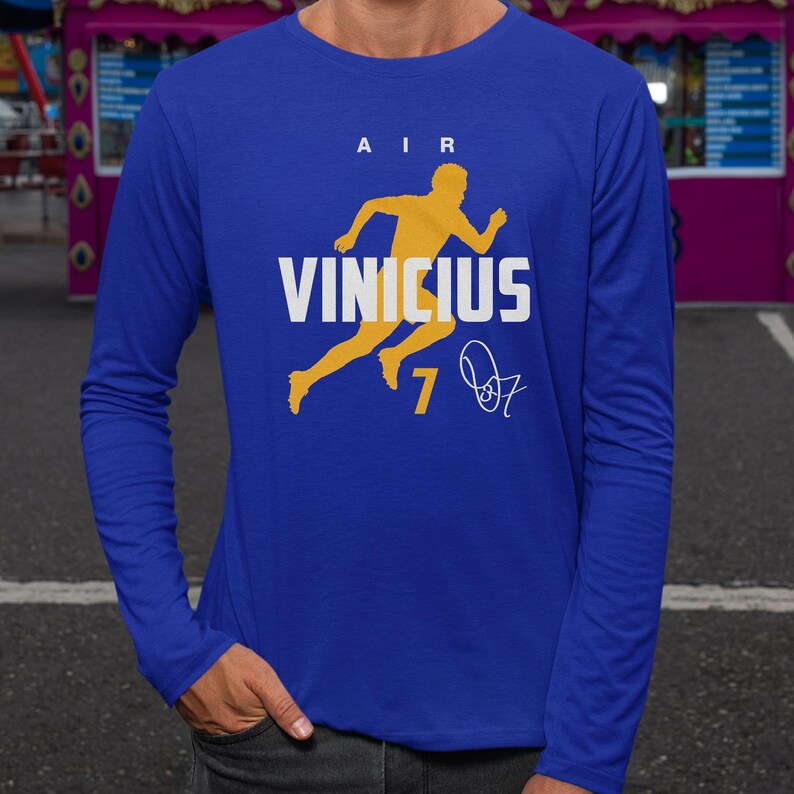 A person wearing a blue long-sleeved shirt with a graphic design featuring a yellow running figure and the text "AIR VINICUS 7" printed on it.