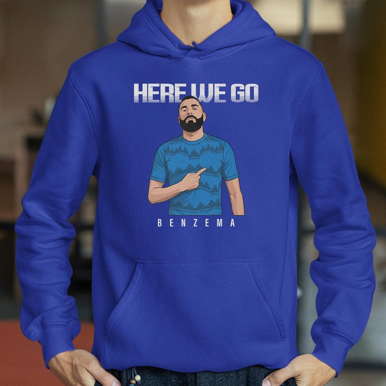 A blue hoodie with a graphic of a man pointing and the text "HERE WE GO BENZEMA" printed on it.