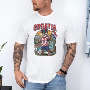 A man wearing a white t-shirt with a graphic of a soccer player and the word "Croatia" printed on it.