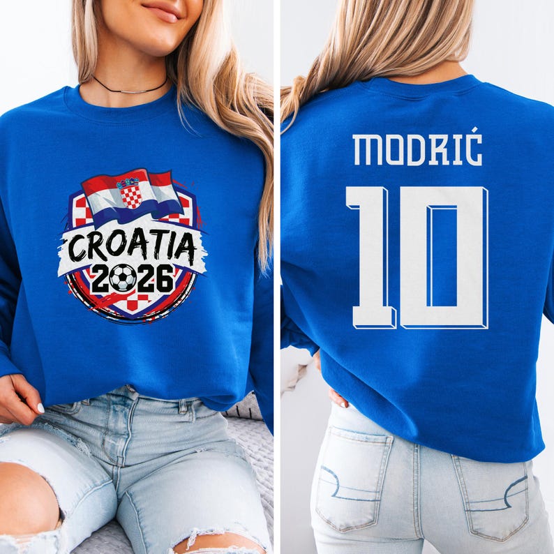 A woman wearing a blue sweater with a graphic of the Croatia national flag and the text "Croatia 2026" printed on it.