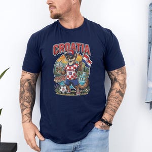 A man wearing a navy blue t-shirt with a graphic of a cat playing soccer and the word "Croatia" printed on it.