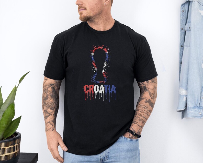 A man wearing a black t-shirt with a graphic design of a trophy and the word "Croatia" printed on it.