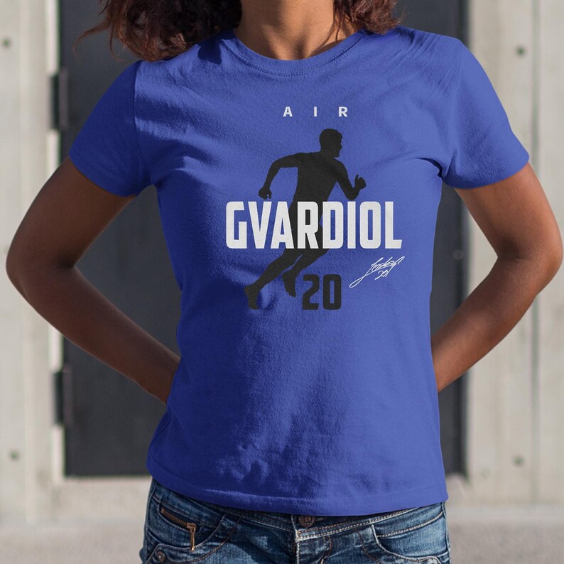 A woman wearing a blue t-shirt with a graphic design and text printed on it.