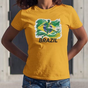 A yellow t-shirt with a graphic of a soccer player and the word "BRAZIL" printed on it.