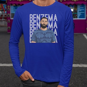 A man wearing a blue long-sleeved shirt with a graphic design featuring the name 'Benzema' repeated across the shirt.