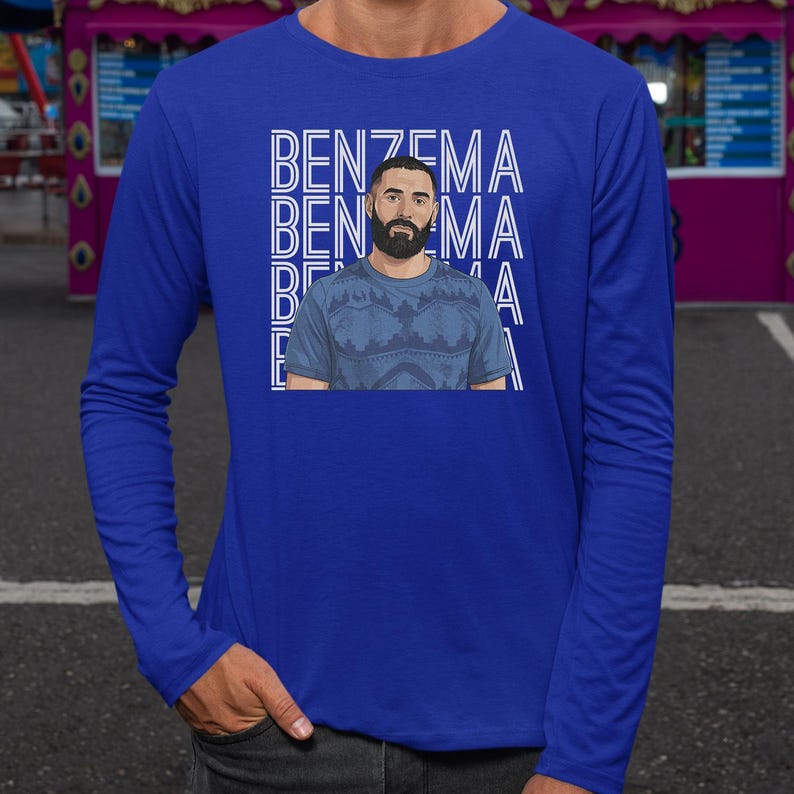 A man wearing a blue long-sleeved shirt with a graphic design featuring the name 'Benzema' repeated across the shirt.