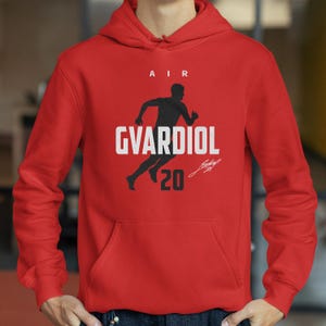A red hoodie with a graphic design featuring a silhouette of a person running and the text "AIR GVARDIOL 20" printed on it.