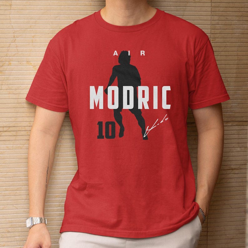 A red t-shirt with a graphic design featuring a silhouette of a person and the text "AIR MODRIC 10" printed on it.