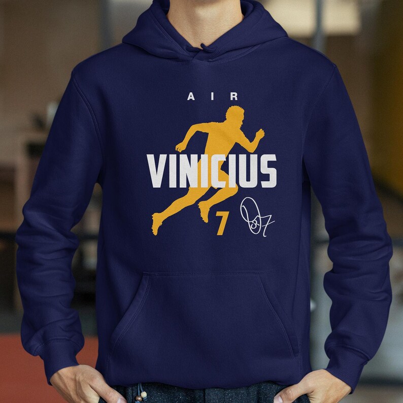 A person wearing a navy blue hoodie with a yellow graphic and text printed on it.