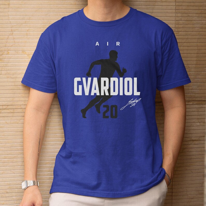 A blue t-shirt with a graphic design featuring a silhouette of a person running and the text "AIR GVARDIOL 20" printed on it.