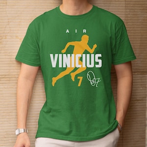 A green t-shirt with a yellow graphic and text printed on it.