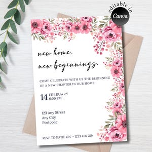 Puede incluir: Una tarjeta de invitación floral con flores rosas y hojas verdes. El texto dice "new home. new beginnings." e incluye la fecha, la hora, la dirección y la información de RSVP. La tarjeta está sobre un sobre marrón claro.