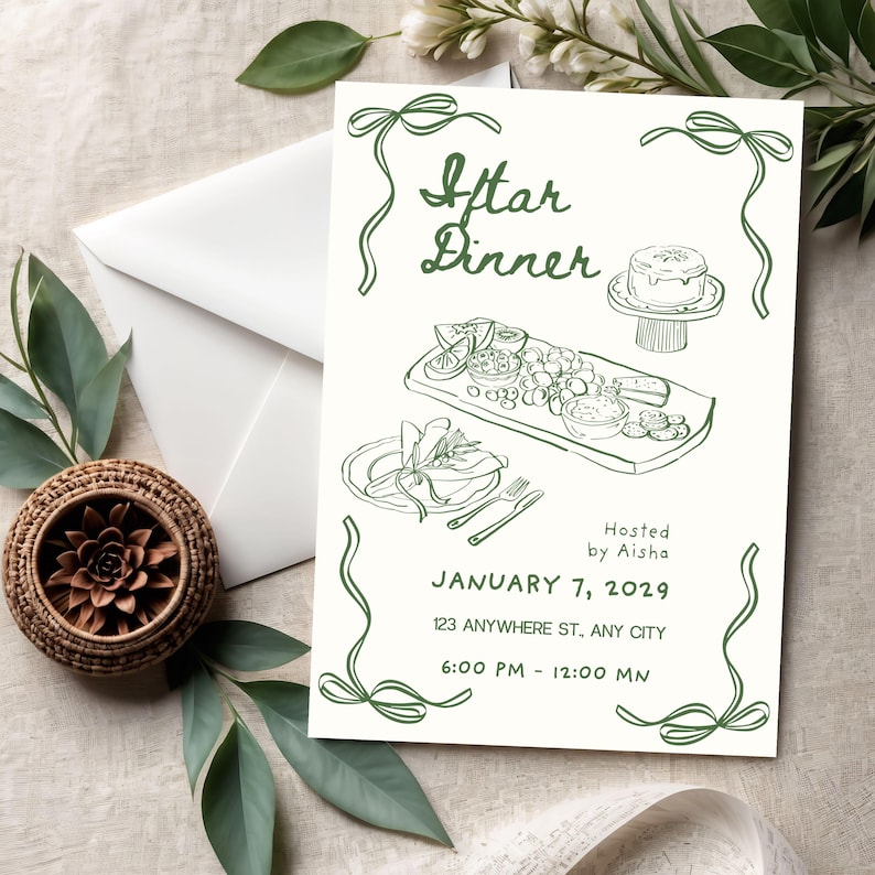 May include: An invitation card with the text "Iftar Dinner" in green script, featuring illustrations of food and a cake. The card includes the date, time, and location, with decorative green bows. A white envelope and a woven basket are also visible.