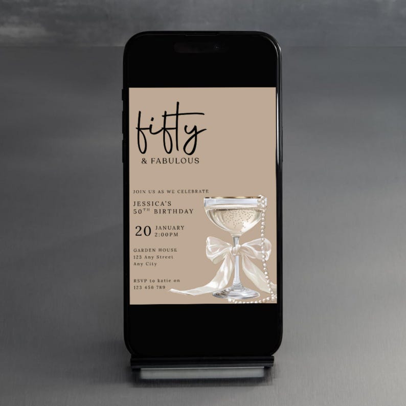 May include: A smartphone displays a digital invitation for a 50th birthday celebration. The invitation features the text "Fifty & Fabulous" in elegant script, a champagne glass, and event details. The background is a neutral beige.