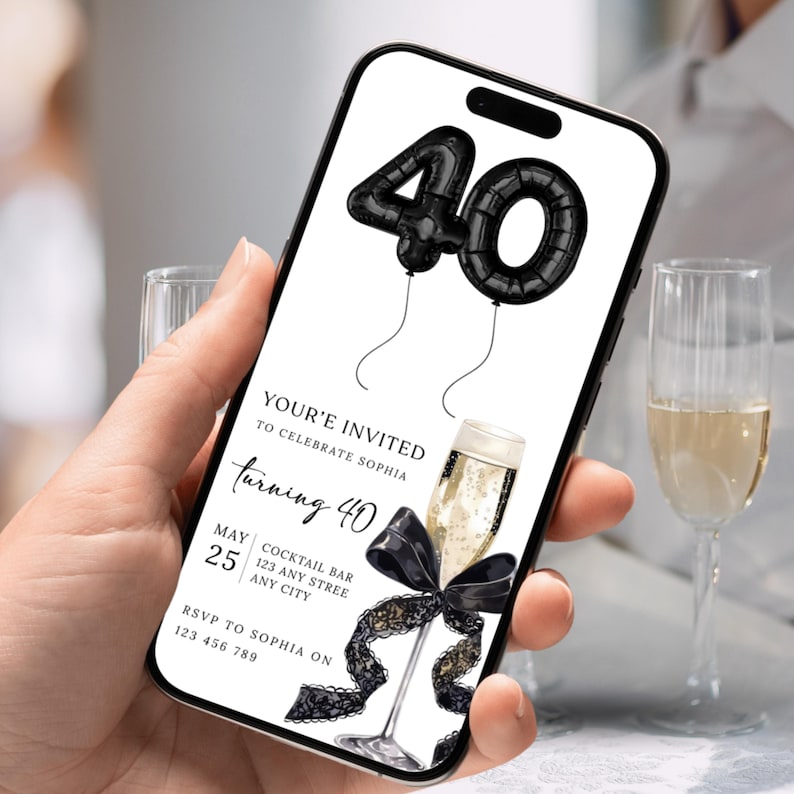 以下が含まれることがあります： スマートフォンには、40歳の誕生日パーティーのデジタル招待状が表示されています。招待状には、黒い風船の数字、黒いリボンが付いたシャンパングラス、イベントの詳細が記載されています。テキストは「You're Invited」と「Turning 40」です。