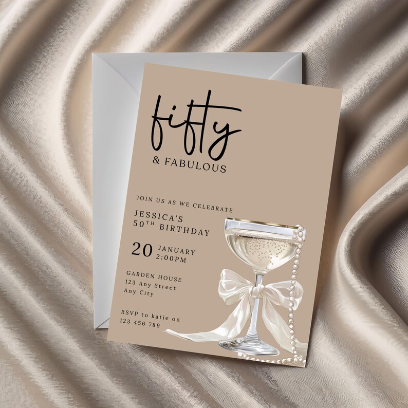 May include: A beige birthday invitation card with the text "fifty & FABULOUS". The card features a champagne glass with a white bow and pearl accents. The invitation includes details for a 50th birthday celebration.
