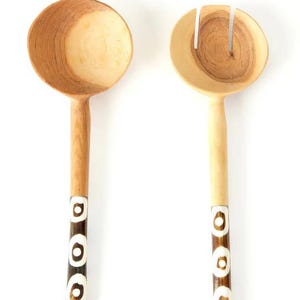 Puede incluir: Una taza de cerámica blanca con un asa negra y el texto "But First, Coffee" en negro y negrita. La taza está sobre una superficie de madera.