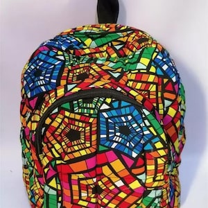 May include: A colorful backpack with a vibrant stained-glass pattern in shades of red, orange, yellow, green, blue, and purple. The backpack has a black zipper and a black handle. The bag is a rounded shape.