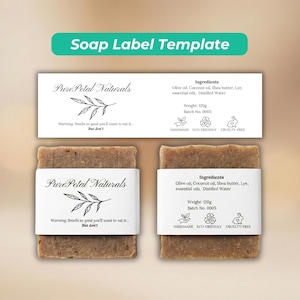 May include: Two bars of handmade soap with white labels. The labels display the text "Pure Petal Naturals" and ingredient details. The labels also include a warning: "Smells so good you'll want to eat it... But don't."