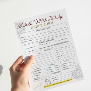 May include: A Sweet Whisk Bakery order form with customer info fields, order details, and payment options. The form includes options for cake sizes, delivery, and a thank you message. The form is held by a hand.