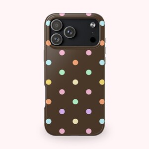 May include: A brown phone case with a repeating pattern of colorful polka dots in pastel shades of pink, yellow, orange, green, and blue. The case has a camera cutout and side buttons.