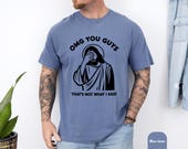 Photo 6 of 8: Man wearing a soft vintage wash blue unisex funny tshirt showcasing a bold black Jesus facepalm graphic and the phrase OMG YOU GUYS, a sarcastic Christian humor tee and meme graphic tee perfect as a novelty gift for Christians who love edgy humor