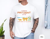 Photo 6 of 10: Bearded hiker wearing a charcoal unisex funny shirt with pixel art console and cheeky "born in the 1900s" aging humor slogan, cozy retro gaming tee with distressed vintage look, soft cotton feel and novelty joke style perfect as a gift for Gen X or millennial gamers