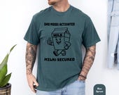 Photo 4 of 8: Funny dad shirt in blue spruce featuring a milk carton art graphic with “Dad Mode Activated” and “Milk Secured,” a playful cereal run joke and cool papa outfit idea for father’s day gift, gag gift for dad, or everyday parenthood apparel