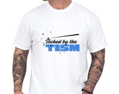 Photo 1 of 8: White vintage wash tee with bold “touched by the tism” graphic in blue and black, styled for neurodivergent shirt and autism humor shirt fans, a funny autism tee with a clean modern look and great as an ASD awareness gift