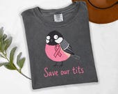 Photo 7 of 17: A folded dark grey t-shirt with a cartoon bird graphic and pink lettering.