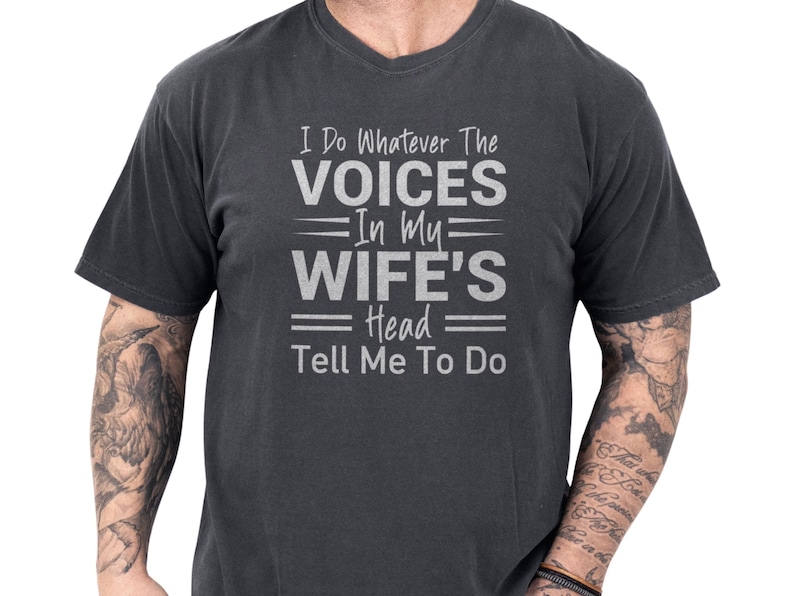 Soft charcoal vintage wash unisex tee with distressed white text reading I do whatever the voices in my wife's head tell me to do, a wife voices shirt and witty slogan shirt blending husband humor and married life humor, funny marriage tee and novelty quote tee perfect as a gag gift for husband and casual everyday wear