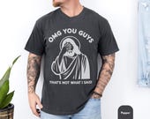 Photo 2 of 8: Male model wearing a soft vintage wash charcoal omg you guys shirt featuring a Jesus facepalm tee graphic and cheeky "That's not what I said" caption, a unisex funny tshirt blending Christian humor and edgy dark humor, great gift for Christians