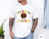Photo 4 of 8: Collage of five available colors for a unisex humor tee shown on a casual model — Black, White, Pepper, Moss, Blue Jean — mockup for a thankful for you Friendsgiving shirt, a funny Thanksgiving parody and rude shirt gift idea for friends