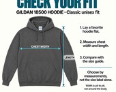 Photo 14 of 20: A fitting guide displaying a dark gray Gildan 18500 hoodie with arrows marking the chest width and length.