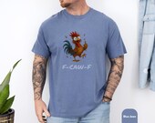 Photo 6 of 8: Man wearing a soft Comfort Colors graphic tee with a cheeky cartoon rooster giving the middle finger and playful 'F-CAW-F' text, an edgy funny t shirt and statement tee for casual streetwear or protest, cozy worn-in look, perfect gift for him or gift for dad