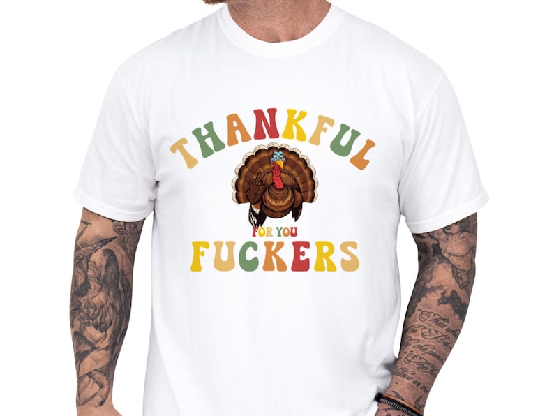 Casual unisex humor tee on a model featuring a retro turkey illustration and colorful lettering saying Thankful for you fuckers, a cheeky friendsgiving shirt and inappropriate rude shirt idea for funny thanksgiving gifts, soft cotton cozy fit ideal as a gift for friends